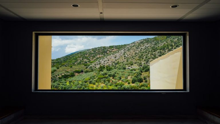 Beautiful mountain landscape seen through a large window in a modern interior setting.